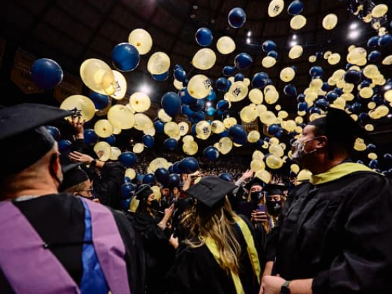 Hundreds of balloons fall atop college students in graduation gowns at Montana State University's fall 2021 commencement ceremony.  | MSU