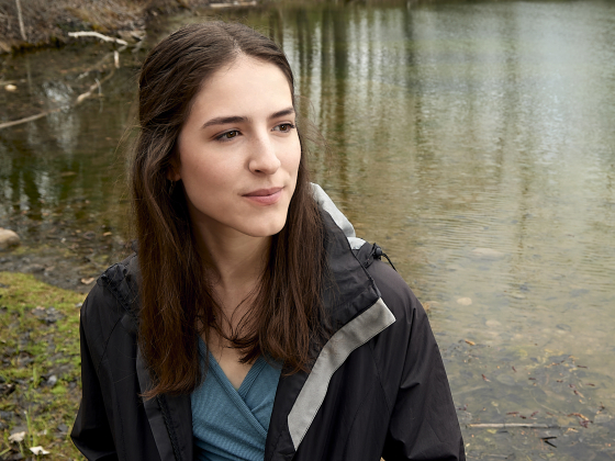 Pilar Santos standing on the edge of a pond looking towards the water. | MSU photo by Kelly Gorham