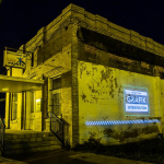 A projection with the words Grafik Intervention is displayed on the side of a building at night