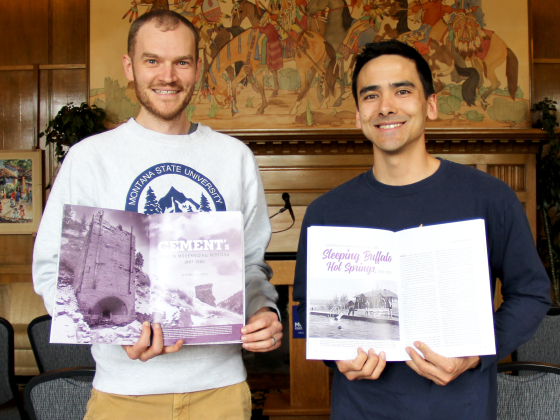 Two men hold open magazine pages while posing for a photo inside the Leigh Lounge. | Submitted photo
