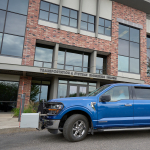 A large blue truck in front of a building
