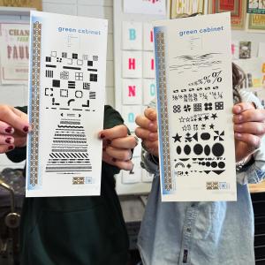 Two people holding books toward the camera