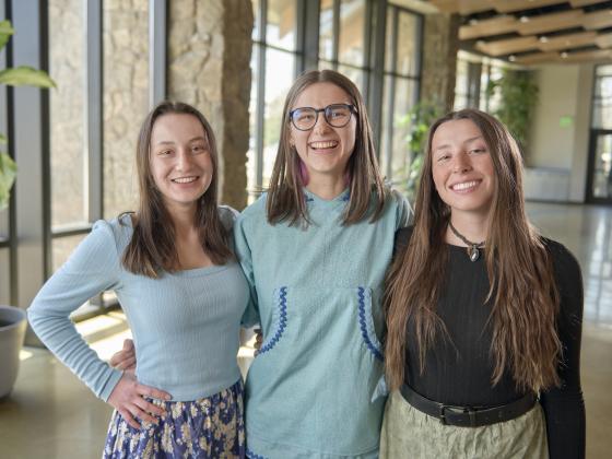 A trio of women stand together arm-in-arm while looking at the camera | MSU photo by Colter Peterson