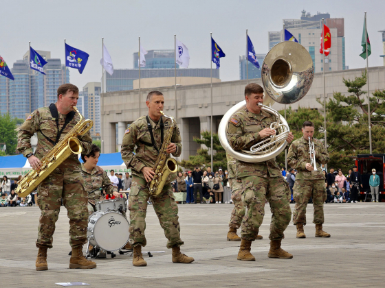 A group of people wearing U.S. Army uniforms performing music with brass instruments in a public area. |  Photo courtesy Sophia Brattoli