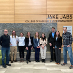 MSU faculty and students from launch pad stand in front of Jake Jabs sign