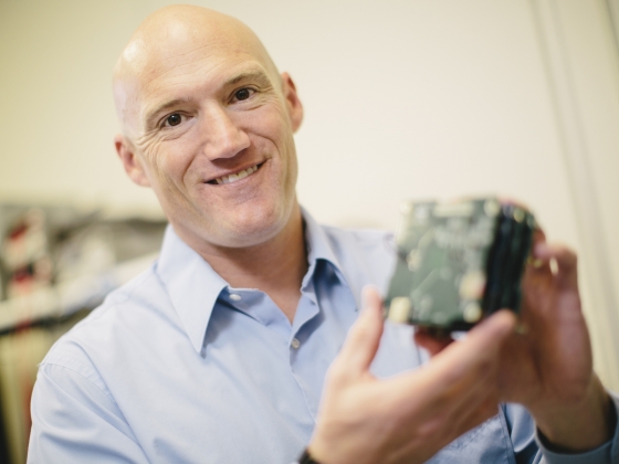 Brock LaMeres holds a component of a RadPC prototype