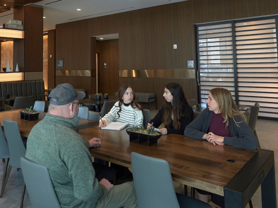 Four people sitting around a table in a hotel lobby | MSU photo by Kelly Gorham