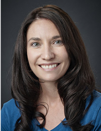 a smiling woman with long brown hair wearing a blue top