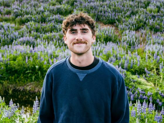 Miles Sumner is photographed in front of a field of lupines.  | Submitted photo