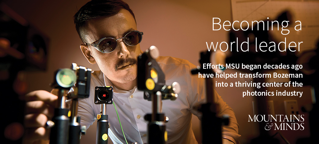 A man in safety goggles adjusts lasers on a laboratory table.  | MSU