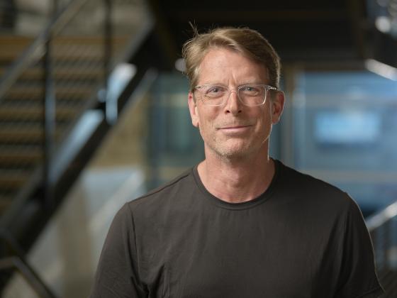 A man stands in front of an out of focus background, smiling at the camera | MSU photo by Colter Peterson