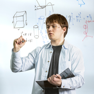 Zane Nordwick writing math equations on a glass wall.