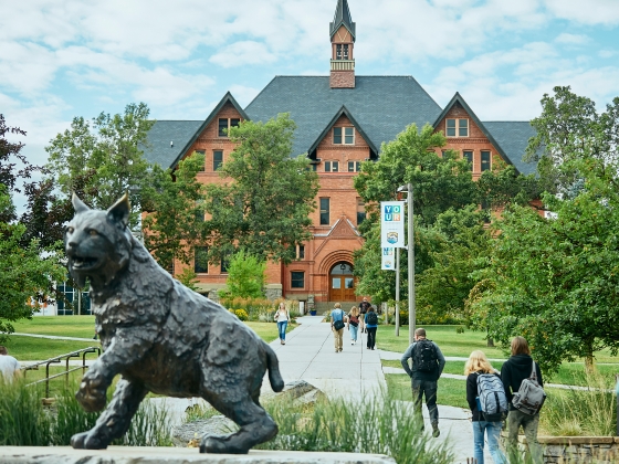 Students walk toward Montana Hall on the Montana State University campus in fall 2019. The statue of Spirit the Bobcat sits in the foreground to the left.  | Adrian Sanchez-Gonzalez/MSU