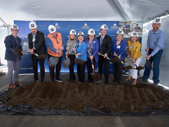 A group shovels dirt during a ceremonial groundbreaking ceremony. | 
