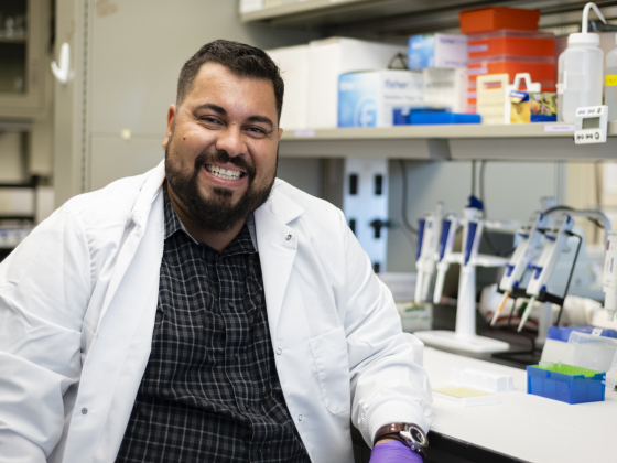 Rodrigo Marques sitting in a lab with lab jacket. | MSU photo by Ty Kernea