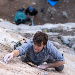 A young man climbs a rock wall