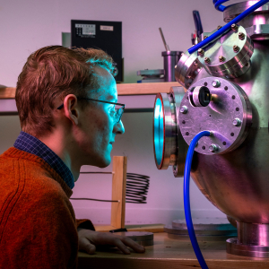 Tristan Sampley looking into a technical piece of laboratory equipment