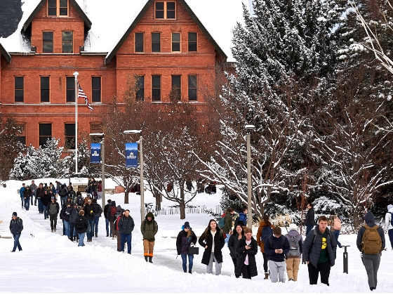 Students walk along a sidewalk at a college campus in winter. | MSU