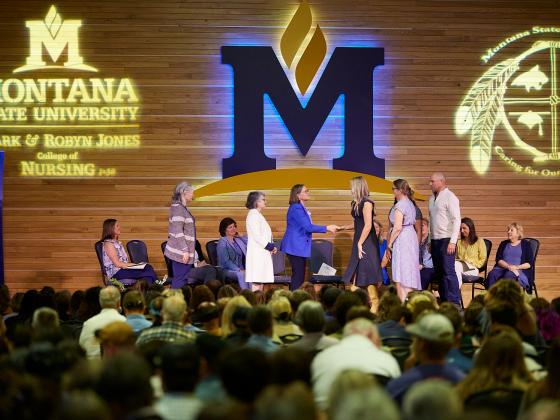A view of several people on a stage greeting a student  | MSU photo by Marcus "Doc" Cravens