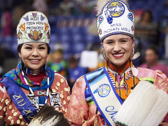 Two women in traditional American Indian regalia pose side by side | MSU photo by Kelly Gorham