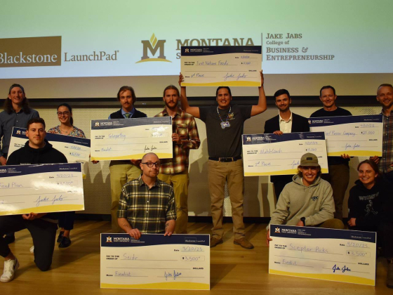 Entrepreneurs pose with extra large checks after a venture competition. | 