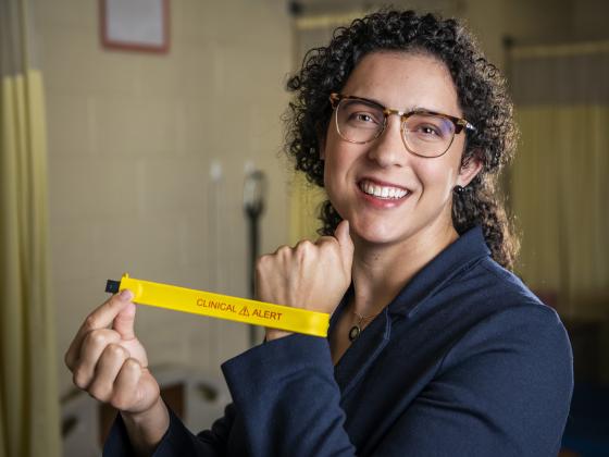 Portrait of Liz Johnson smiling and holding a yellow device | MSU photo by Colter Peterson