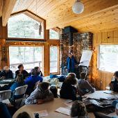 Students in a rustic building listening to a presenter