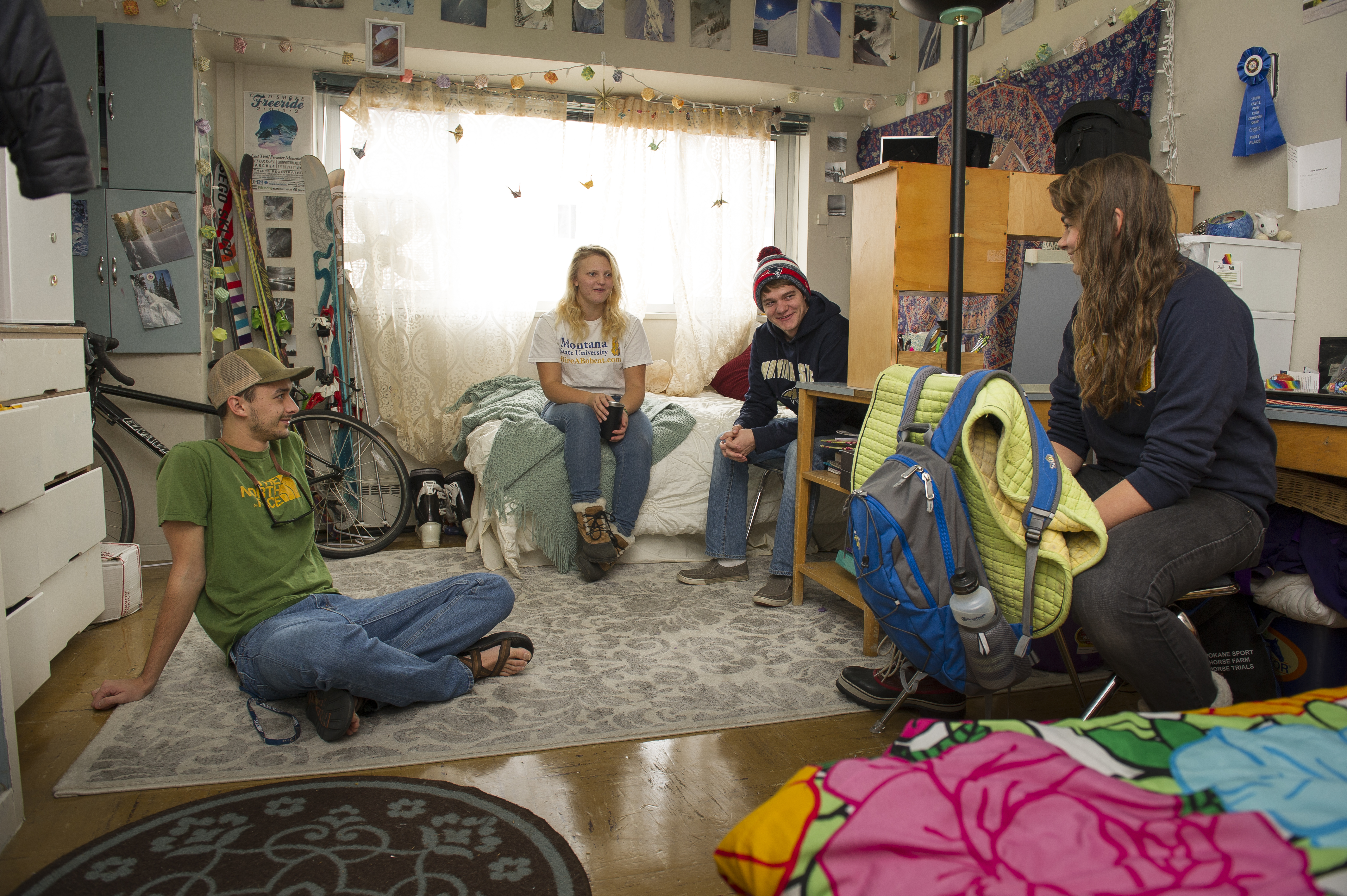 A picture of a group of students having a conversation in a dorm room