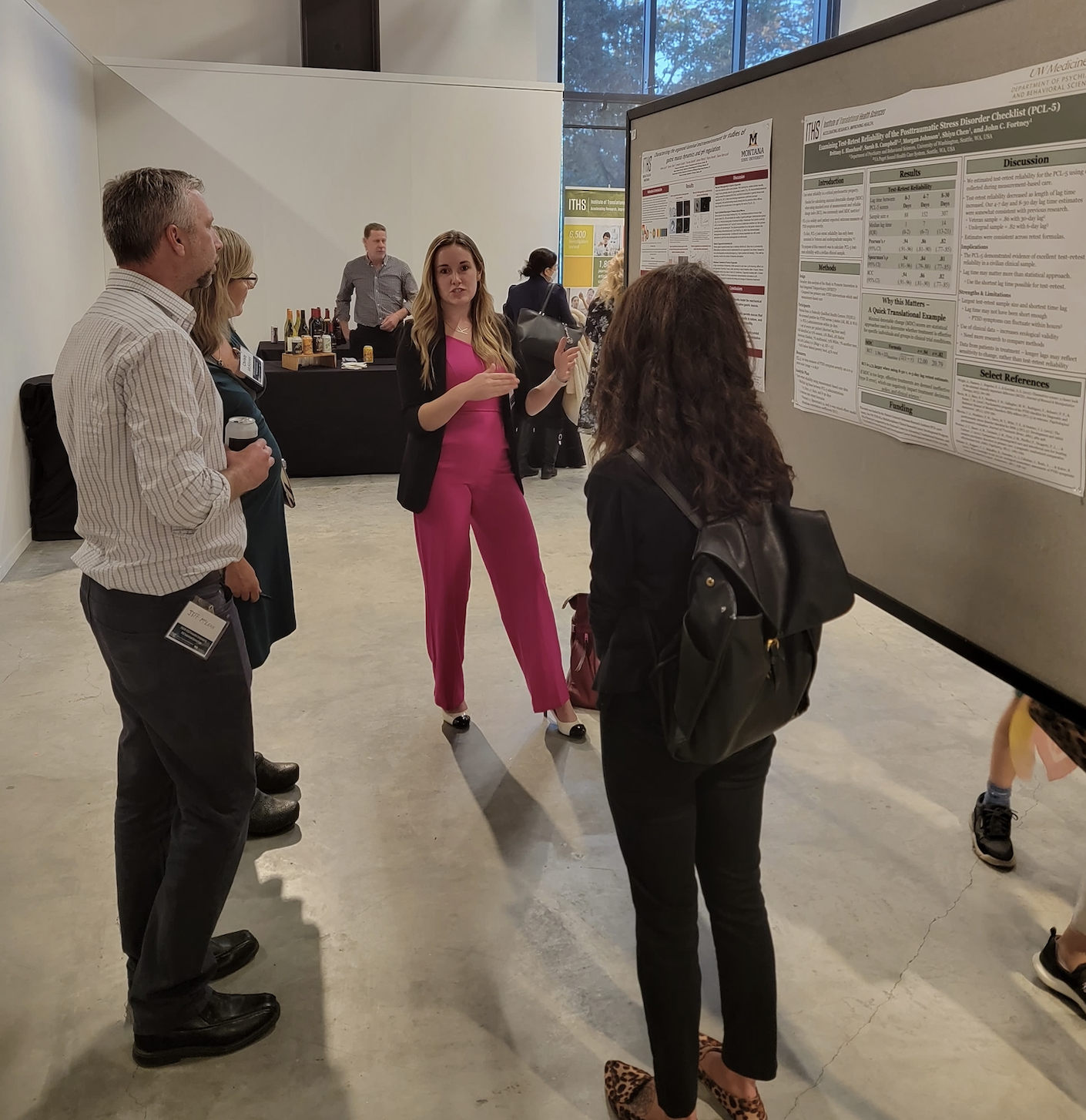 Katrina talking with colleagues at her poster