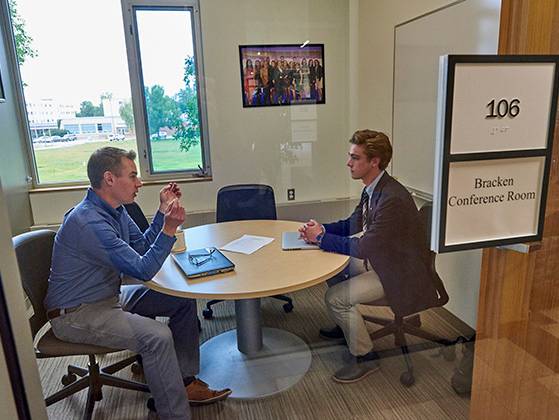 Alumni coaching a student in a Bracken Center conference room