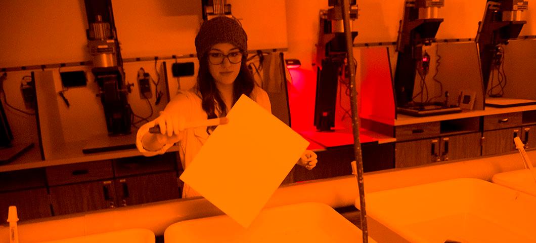 A girl in a developing room working on developing photos