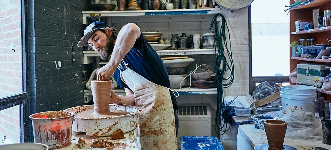 Man making pottery in a studio