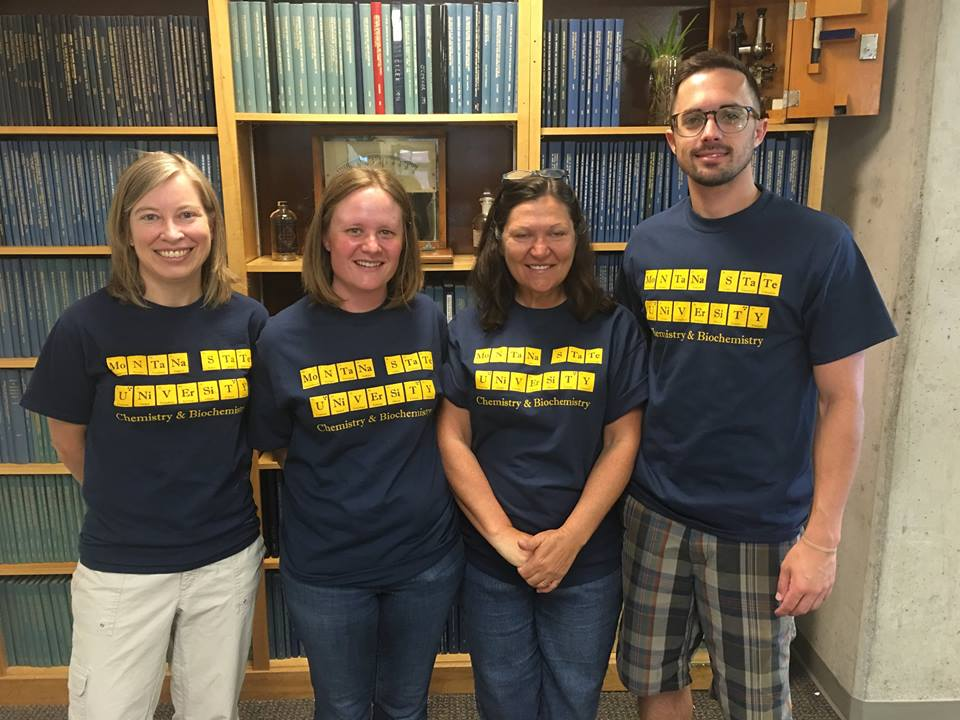 4 faculty memembers showing off Chemistry and Biochemistry department shirts