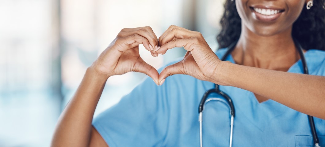 woman with stethoscope, making heart shape with hands