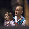 Shane Doyle holds his daughter, Lilian, as he waits to sing an honor song at Montana State University. (MSU photo by Kelly Gorham). 