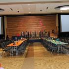 Image of decorated long tables with balloons in foreground and projector screens in the background.