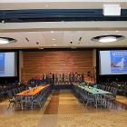 Image of decorated long tables with balloons in foreground and projector screens in the background.