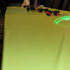 Low angle image of decorated table with sunglasses and bright yellow tablecloth.