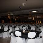 Image of decorated round tables. Rounded rectangles and disco balls hang from the ceiling