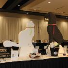 Image of white cat and black dog sculptures on table.