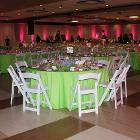 Image of round table 29 with green tablecloth and other tables in the background. Walls are lit with magenta floor lights.