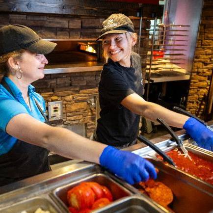 student employees making pizza