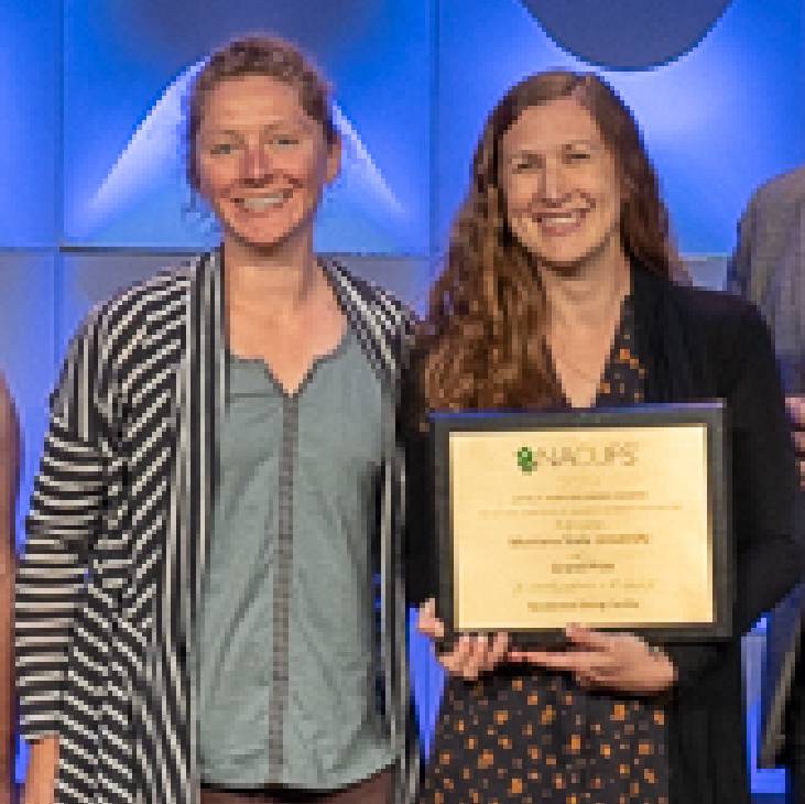 staff members smiling and holding an award plaque