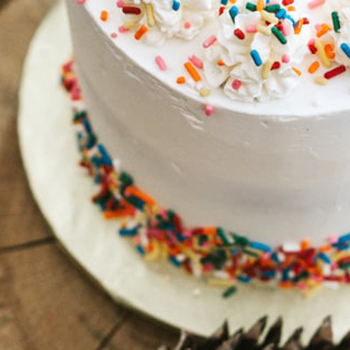 white birthday cake with rainbow sprinkles