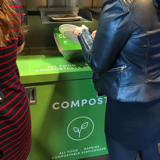 stduent dumping food waste into a compost bin