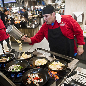 chef cooking pasta in skillets