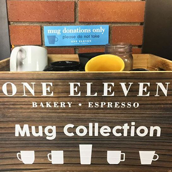 wooden bin full of ceramic coffee mugs