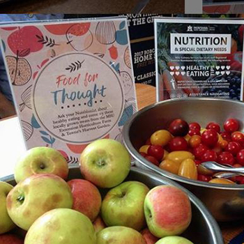 table of fresh apples and signs about nutrition