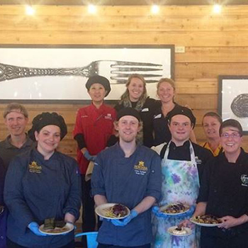 staff holding plated meals