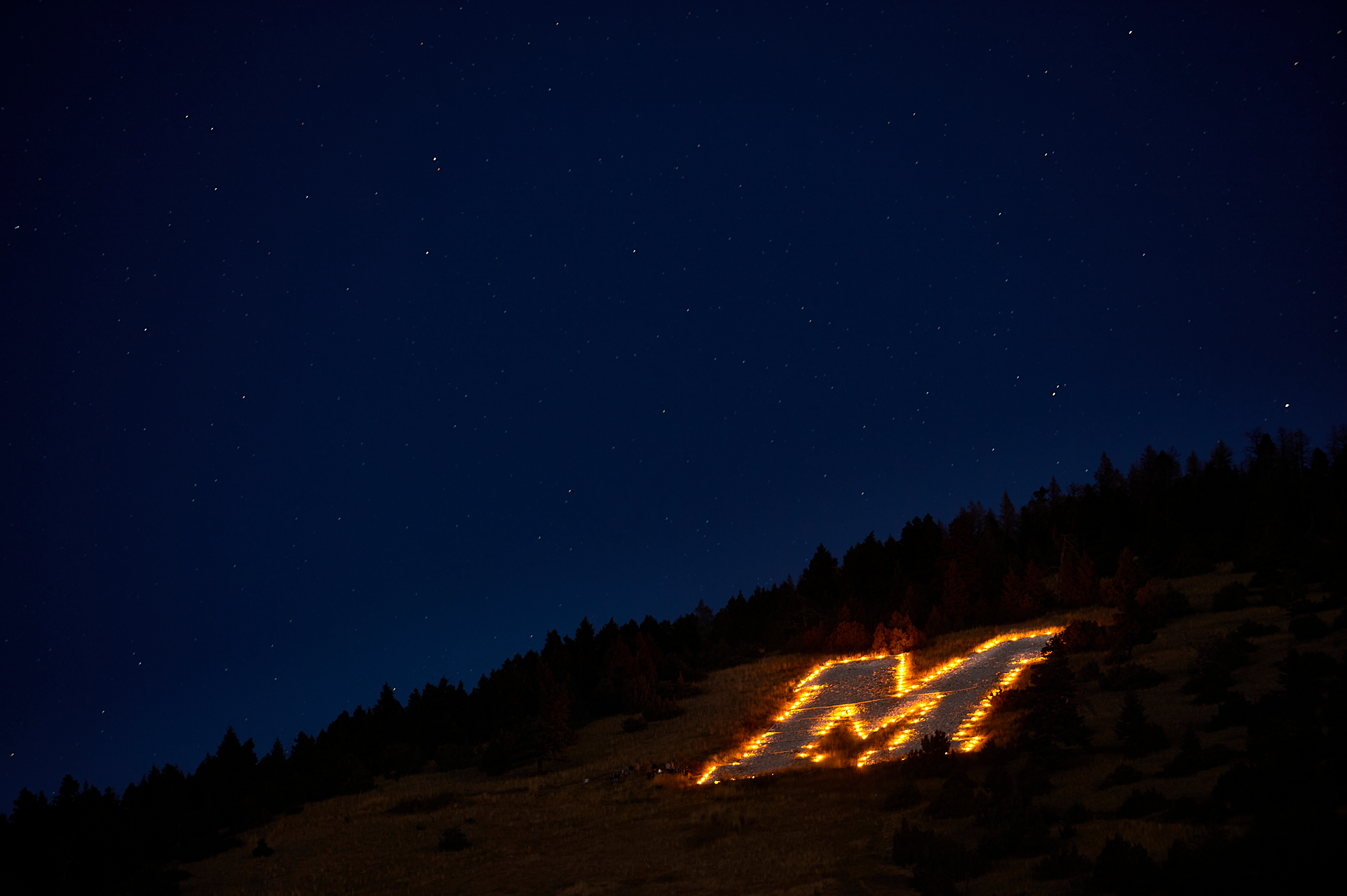 the "M" on the side of the mountain in Bozeman at night with the outline illuminated by candles